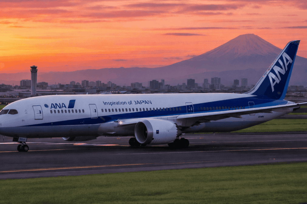สายการบินของญี่ปุ่น All Nippon Airways (ANA) เครื่องบิน Boeing 787 กำลังวิ่งบนรันเวย์ โดยมีภูเขาไฟฟูจิและท้องฟ้ายามพระอาทิตย์ตกเป็นฉากหลังในประเทศญี่ปุ่น ✈️🇯🇵