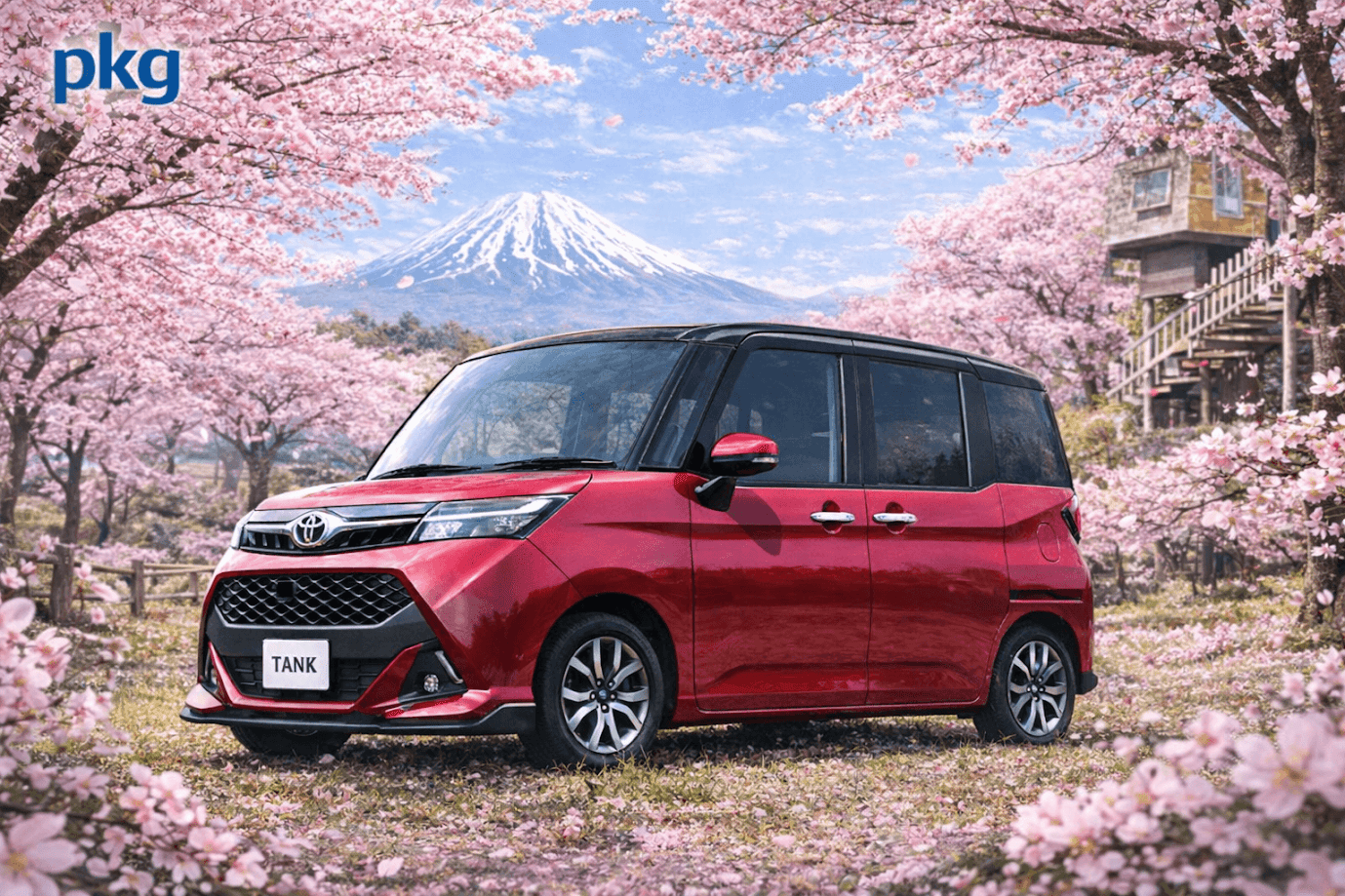 รถยนต์ Toyota Tank สีแดงจอดอยู่ท่ามกลางสวนซากุระที่กำลังบานสะพรั่ง มีภูเขาฟูจิที่มียอดปกคลุมด้วยหิมะอยู่ด้านหลัง ภายใต้ท้องฟ้าสีฟ้าใส กลีบดอกซากุระสีชมพูโปรยปรายทั่วพื้นหญ้า และมีบ้านไม้ยกสูงอยู่ด้านขวา มุมซ้ายบนของภาพมีโลโก้คำว่า “pkg” สีฟ้าอยู่บนพื้นหลังท้องฟ้า