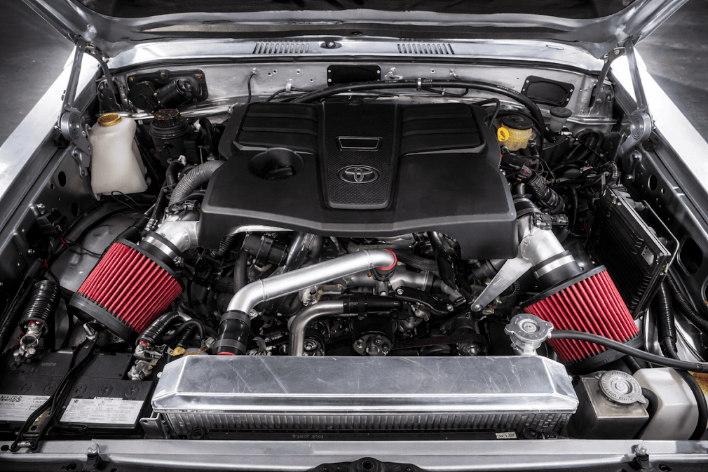 ห้องเครื่อง Toyota แบบปรับแต่ง มีกรองอากาศสีแดงคู่และท่ออินเตอร์คูลเลอร์อะลูมิเนียม เน้นความแรงและสมรรถนะของเครื่องยนต์ เครื่อง Toyota ดีไหม