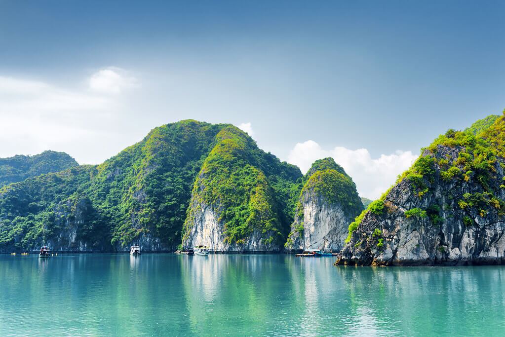 ภาพทิวทัศน์อ่าวฮาลอง (Halong Bay) ที่เที่ยวเวียดนาม แสดงเกาะหินปูนสีเขียวและเรือท่องเที่ยวในทะเลสีมรกต