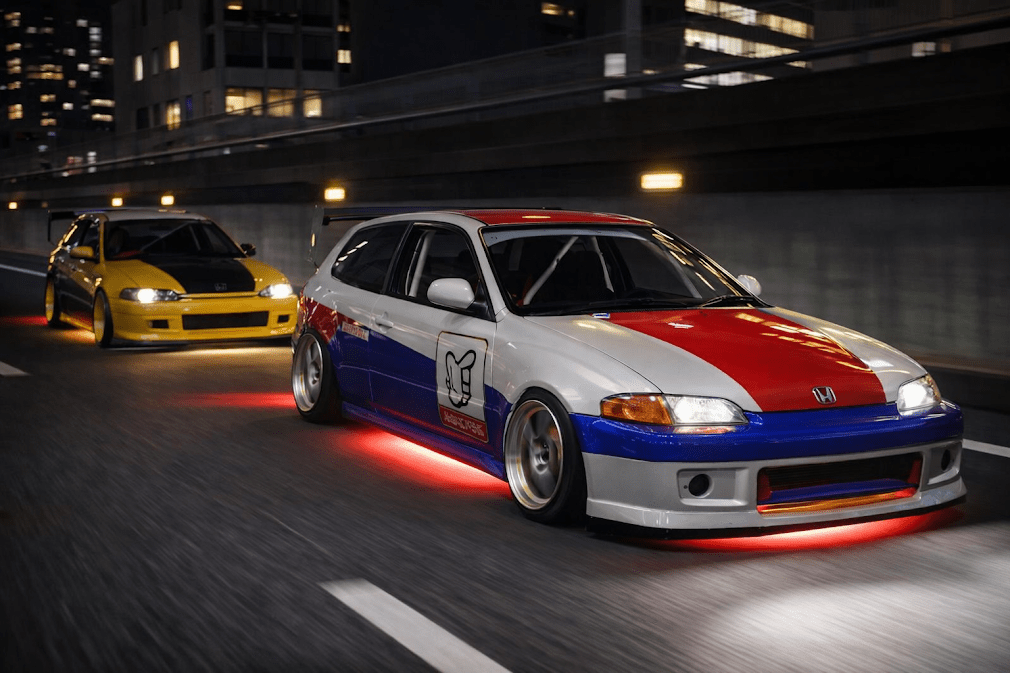 kanjozoku คืออะไร มีที่มาอย่างไร — ภาพรถแต่งสไตล์ Honda Civic สีขาวแดงน้ำเงิน พร้อมไฟนีออนใต้ท้องรถ ขับบนทางด่วนเมืองญี่ปุ่นยามค่ำคืน มีรถแต่งอีกคันตามหลัง สะท้อนวัฒนธรรมแก๊งรถซิ่งคันโจโซกุที่มีต้นกำเนิดจากการแข่งบนทางด่วนวงแหวนโอซาก้า (Kanjo Loop)