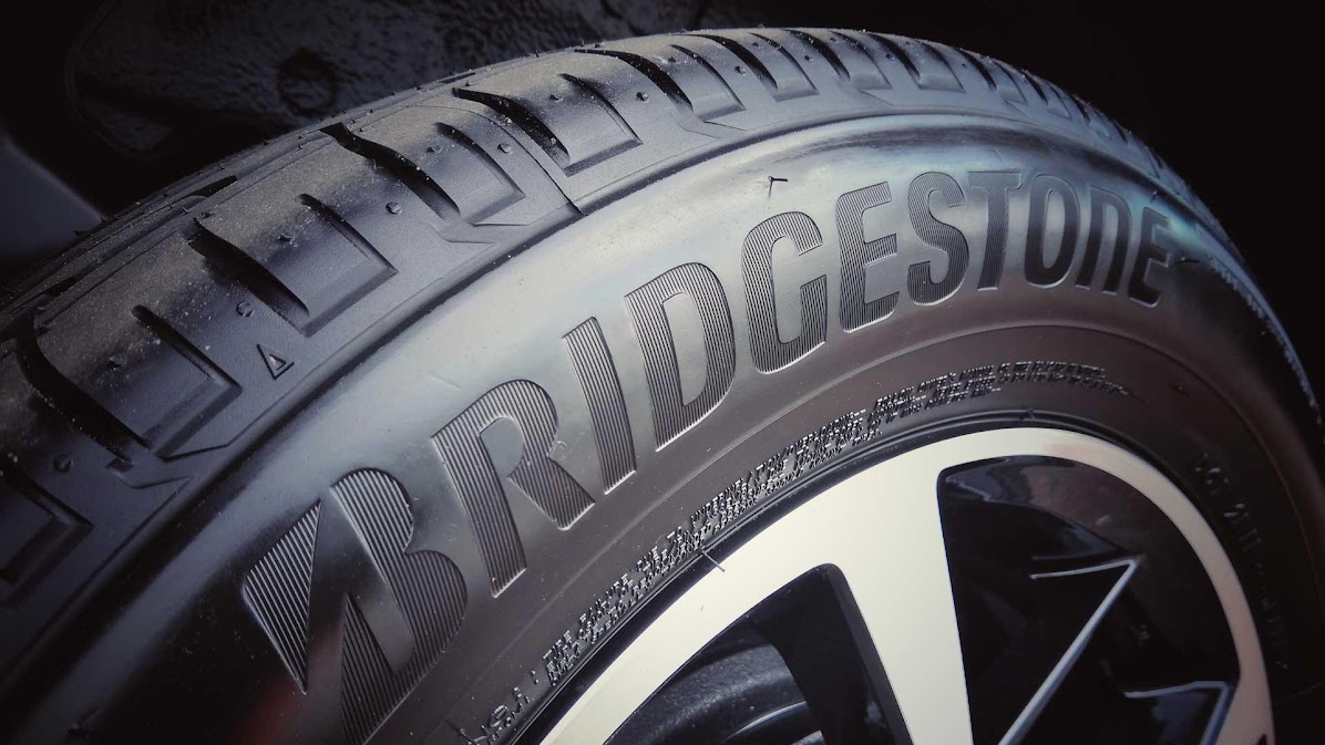 ยางรถยนต์ Bridgestone บนล้อรถ โชว์ดอกยางและโลโก้ชัดเจน สื่อถึง ยี่ห้อยางญี่ปุ่นยอดนิยม ที่มีคุณภาพและความทนทานสูง