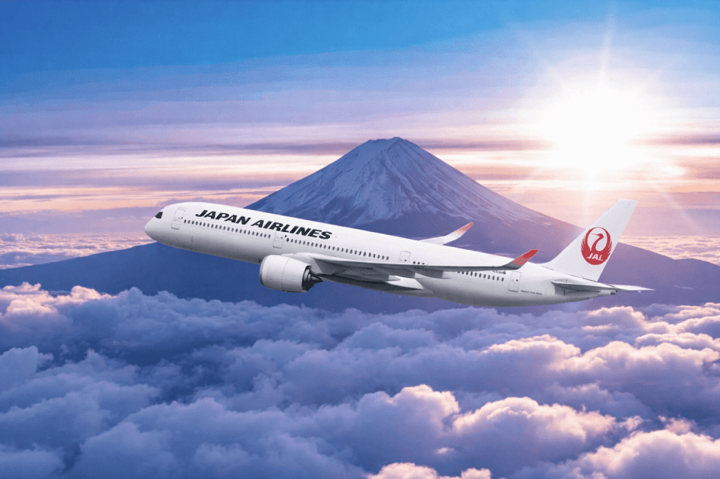 สายการบินของญี่ปุ่น Japan Airlines (JAL) เครื่องบินกำลังบินเหนือกลุ่มเมฆ โดยมีภูเขาไฟฟูจิและแสงพระอาทิตย์เป็นฉากหลัง สะท้อนความงดงามของการเดินทางในประเทศญี่ปุ่น ✈️🇯🇵