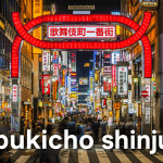 ภาพบรรยากาศยามค่ำคืนใน ย่าน kabukicho ชินจูกุ โตเกียว ประเทศญี่ปุ่น โดดเด่นด้วยซุ้มประตูสีแดง Kabukicho Ichibangai รายล้อมด้วยป้ายไฟนีออน ร้านค้า และผู้คนจำนวนมาก สะท้อนเสน่ห์ไนท์ไลฟ์และความคึกคักของ ย่าน kabukicho แหล่งท่องเที่ยวยอดนิยมในโตเกียว
