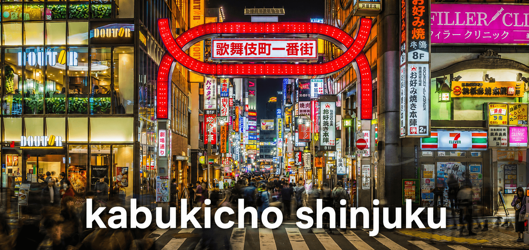 ภาพบรรยากาศยามค่ำคืนใน ย่าน kabukicho ชินจูกุ โตเกียว ประเทศญี่ปุ่น โดดเด่นด้วยซุ้มประตูสีแดง Kabukicho Ichibangai รายล้อมด้วยป้ายไฟนีออน ร้านค้า และผู้คนจำนวนมาก สะท้อนเสน่ห์ไนท์ไลฟ์และความคึกคักของ ย่าน kabukicho แหล่งท่องเที่ยวยอดนิยมในโตเกียว